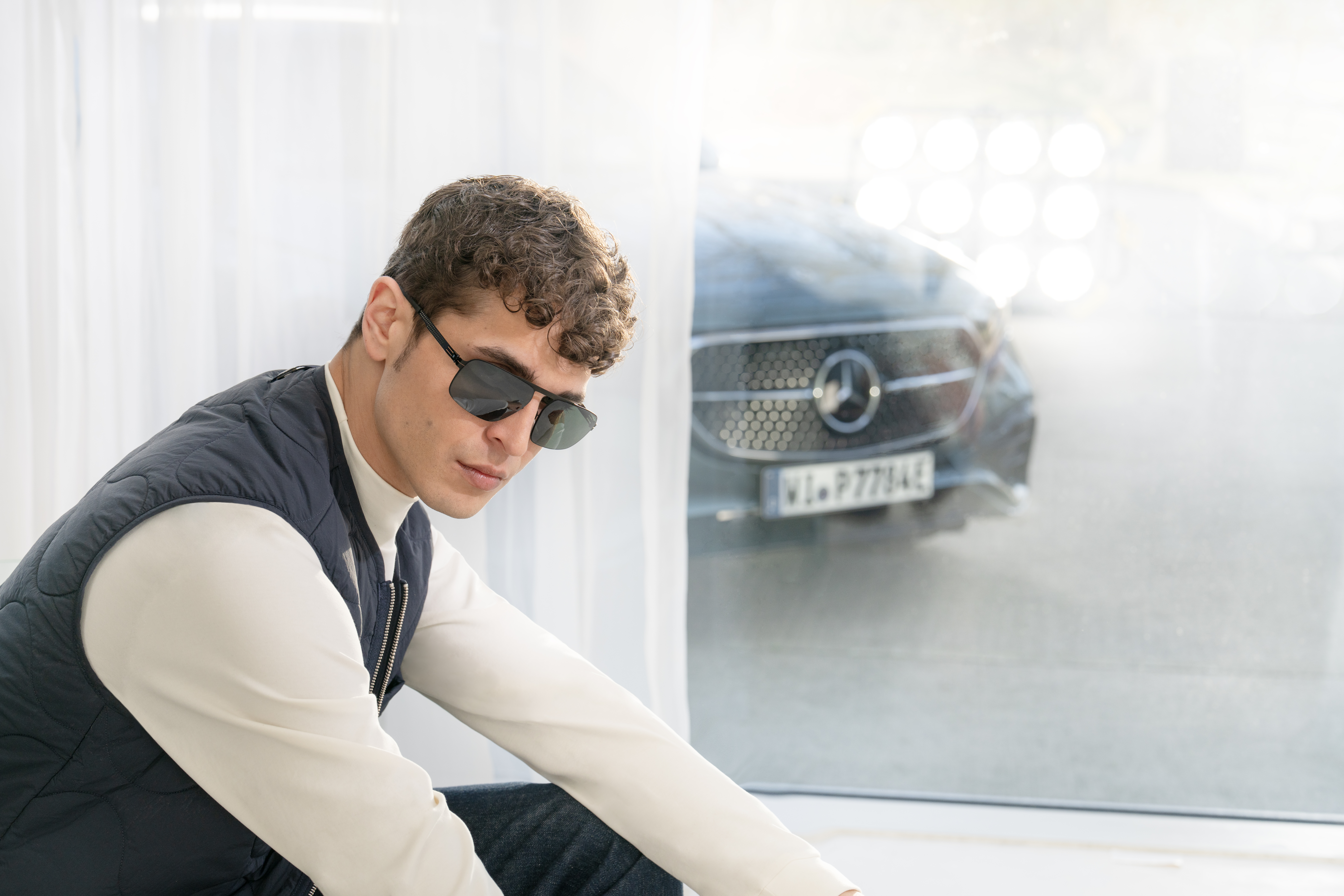 Sleek stainless steel ic! berlin eyeglasses frame on a polished concrete surface in a Berlin industrial loft — screwless hinge design, minimalist luxury eyewear